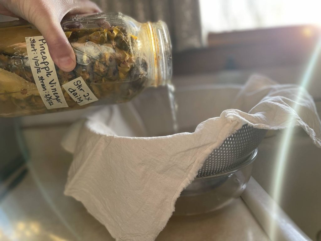 straining pineapple vinegar