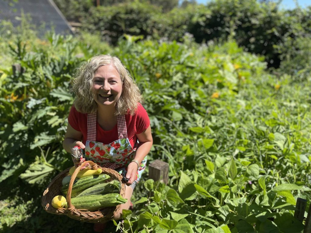 Michele smiles over summer squash harvest